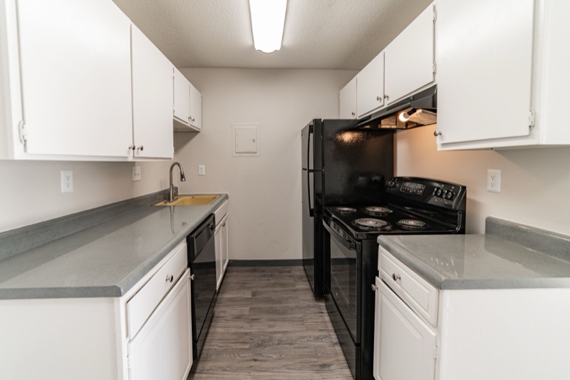 Updated kitchen with white cabinets and gray countertops at The Ridges